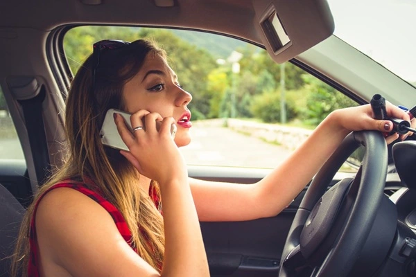 Eine Autofahrerin benutzt Handy am Steuer